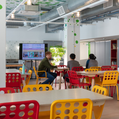 Main space with table, chairs, people and presentation screen.