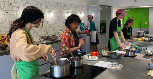 Group of adults cooking in the Nourish Hub training kitchen