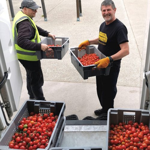 Two UKHarvest team members taking food out of a van.